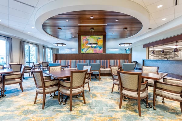 Bright and inviting common area with dining tables