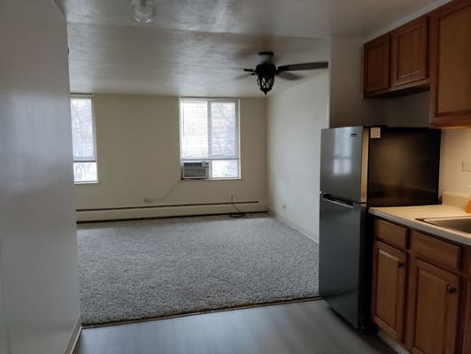 Bright living room with a refrigerator and kitchen area