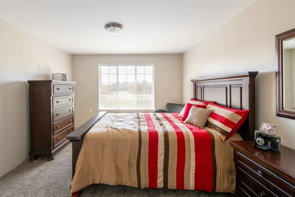 Cozy private bedroom with a made bed and furniture