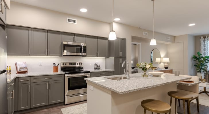 Modern kitchen interior with gray cabinets and granite countertops