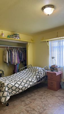 A private resident room with a bed and shelves