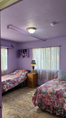 A cozy resident room with two beds and floral bedding