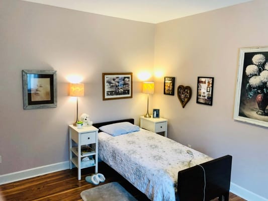 Inviting bedroom with a bed, bedside table, and decorative lamps.