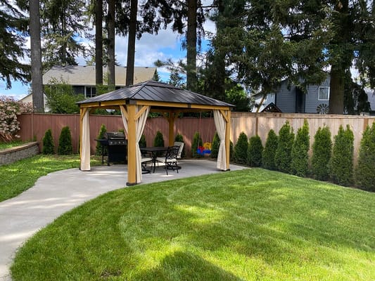 Outdoor garden pavilion with seating and grill