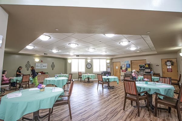 Residents enjoying a dining area with tables set for meals