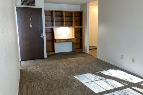 Empty interior room with a door and shelving
