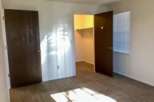 An empty resident room with two doors and a closet