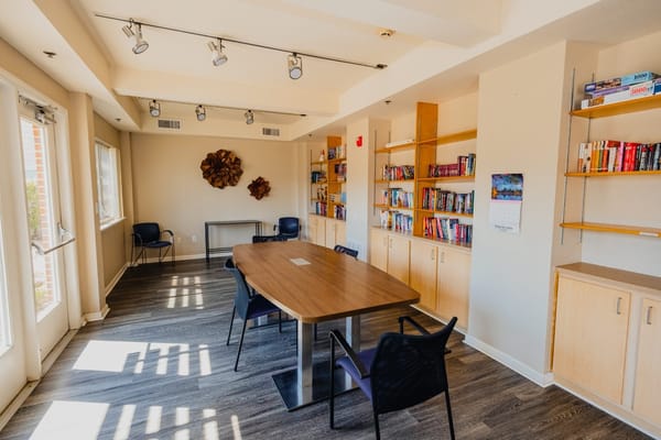 Common area with a large table and bookshelves.
