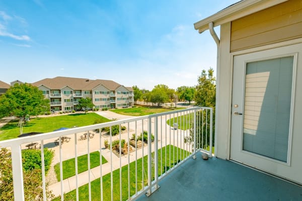 Balcony view of a landscaped courtyard and adjacent buildings