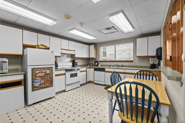 Bright and spacious kitchen with dining table and appliances