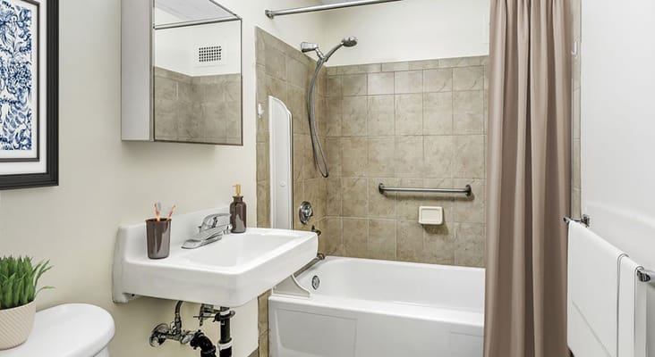A clean and modern bathroom with a bathtub and sink.