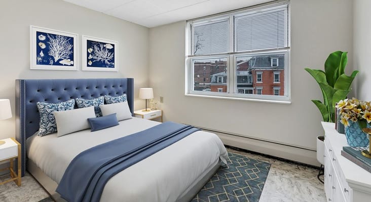 Modern bedroom with a blue upholstered headboard and decorative wall art