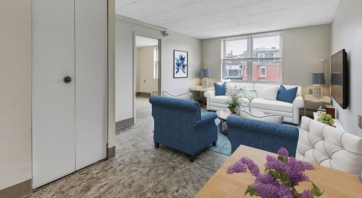 Bright and spacious living room with blue furniture and natural light.