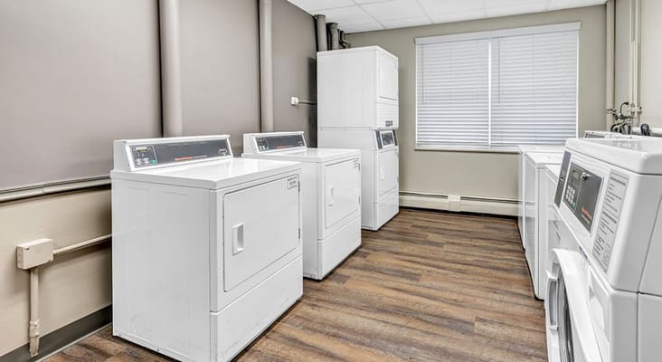 Bright laundry room with multiple washers and dryers.