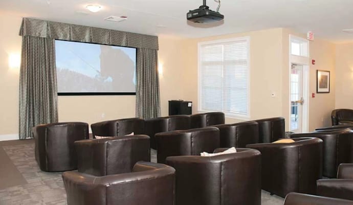 Seating area in the theater room with a projector screen