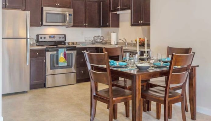 Modern kitchen and dining area with wooden table and appliances