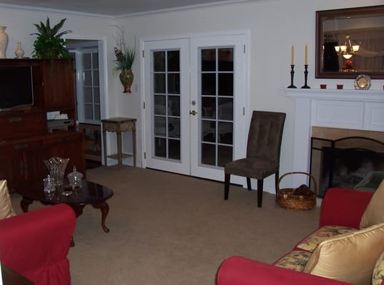 Living room area with a red couch, brown chair, and decorative plants.