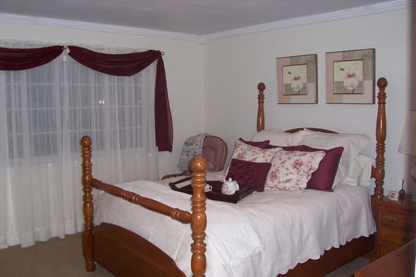 Comfortable bedroom with a wooden bed and decorative pillows