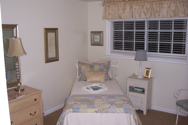 A cozy bedroom with a single bed and bedside table