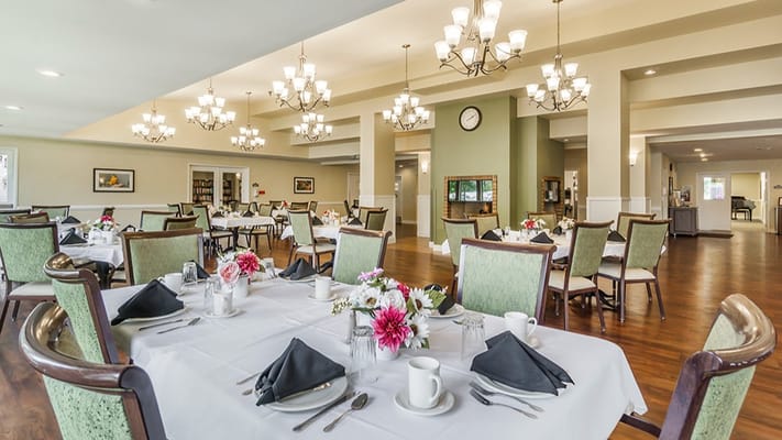 Bright dining room set for a meal with floral centerpieces