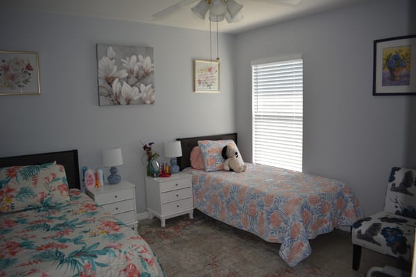 Bright and inviting bedroom with two beds and floral decor