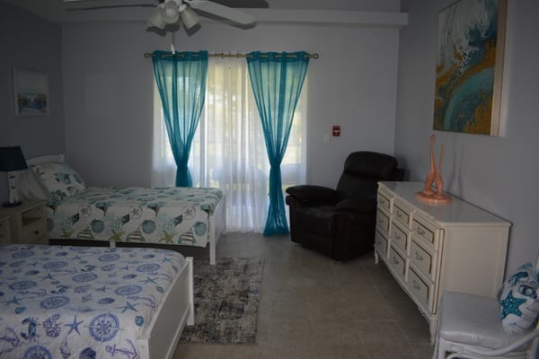 Cozy bedroom featuring two twin beds and a recliner