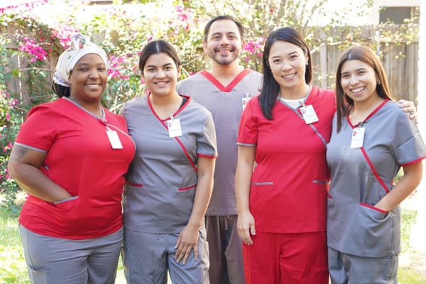 Five staff members posing outdoors at Caring Senior Service