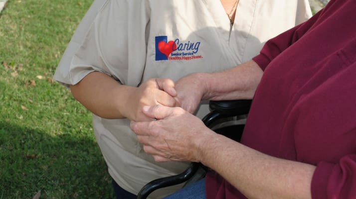 A caregiver holding hands with a senior resident