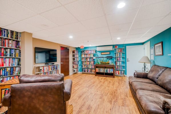 Library lounge with bookshelves, seating, and a fish tank
