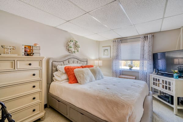 Comfortable bedroom with a bed, dresser, and TV