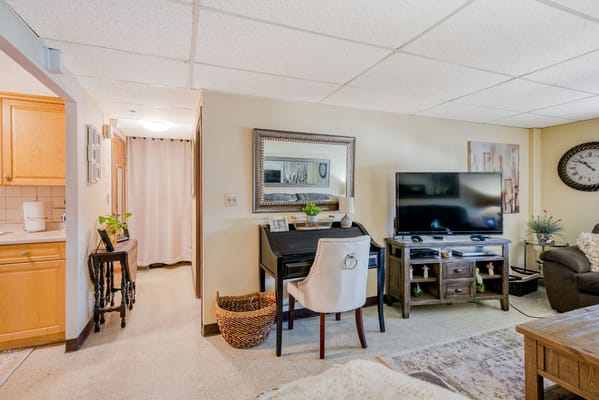 Cozy living room with a desk and television in Kingsway Senior Housing