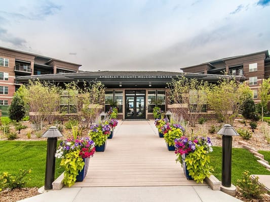 Exterior view of the Amberley Heights Welcome Center with flowers