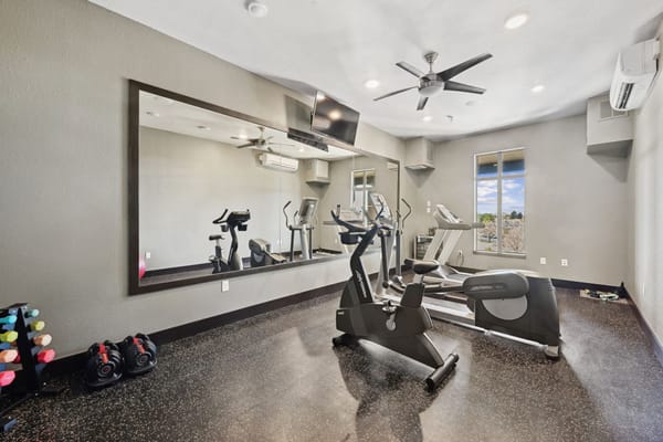 Well-equipped gym with exercise equipment and mirrors