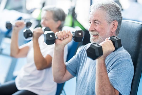 Seniors exercising with dumbbells in a fitness area