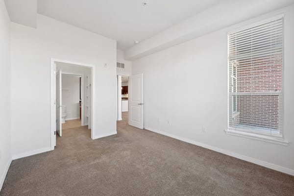 Empty resident room with soft carpet and large window