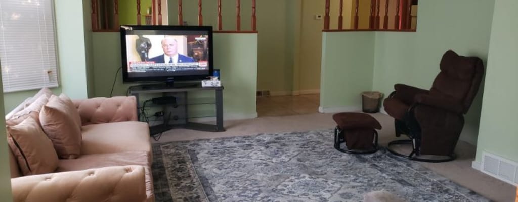 Common area with a couch and TV in a green room