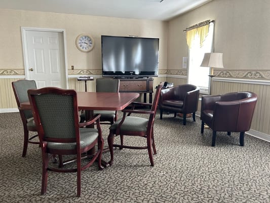 A living room with a table, chairs, and a TV