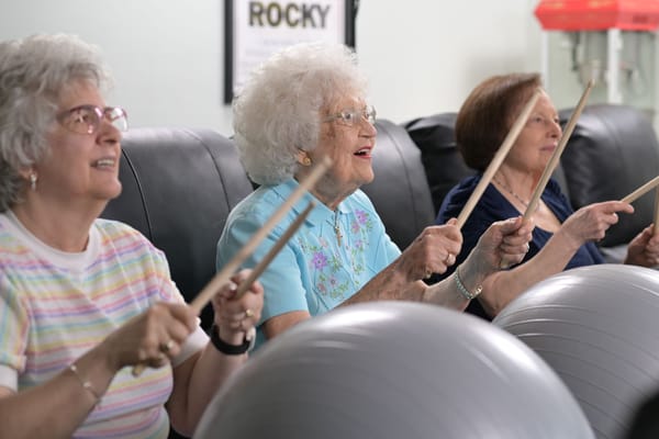 Seniors participating in a drumming activity