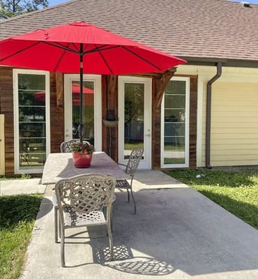Outdoor patio area with red umbrella and table