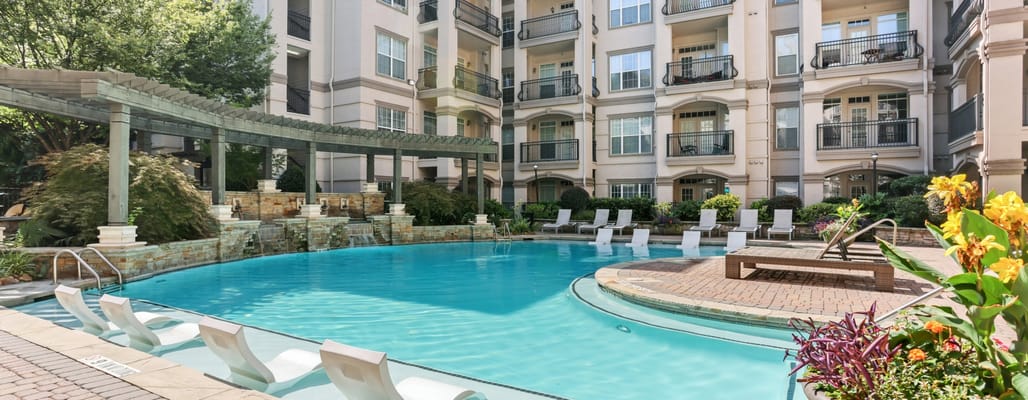 Outdoor pool area with lounge chairs and greenery