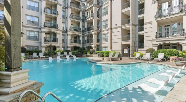 Swimming pool area with lounge chairs and building exterior