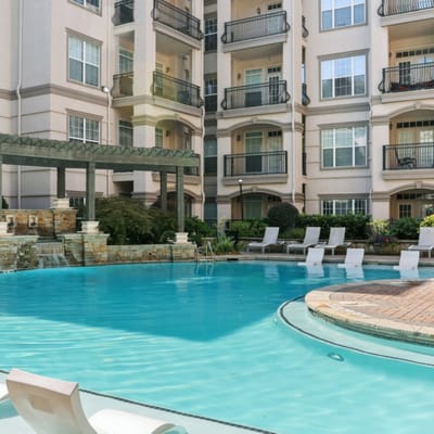 Swimming pool area with lounge chairs and greenery