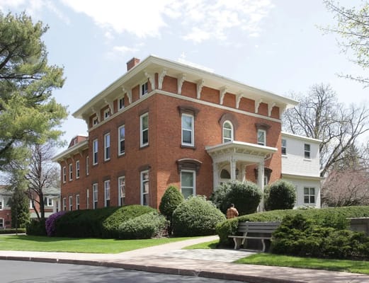 A red brick building surrounded by greenery at Shepherd Park Elderly Housing.