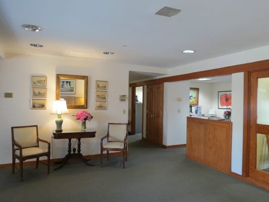 Welcoming lobby with chairs, a table, and artwork
