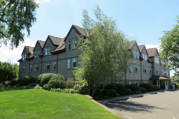 Side view of Hill House with well-maintained lawn and gardens.