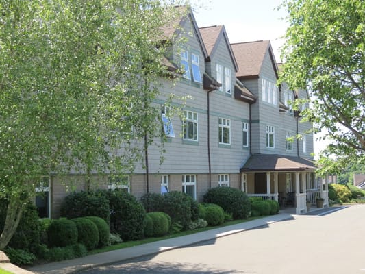 Front view of Hill House senior living facility with landscaped greenery
