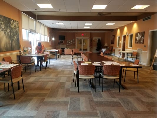 Spacious common room with tables and seating for residents
