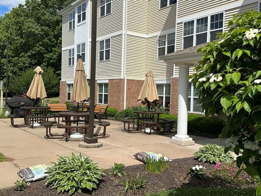 Outdoor patio with picnic tables and umbrellas at Krause Gardens Senior Living.