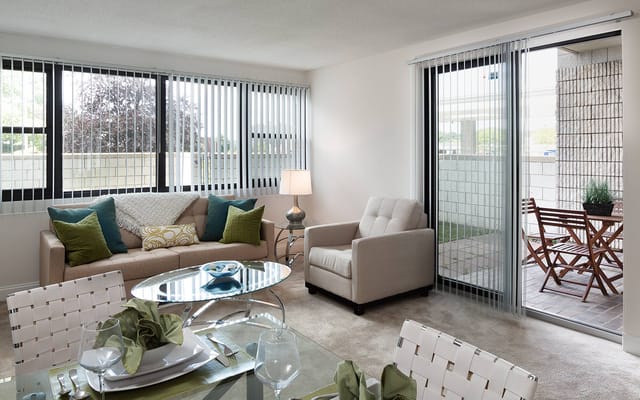 Bright and modern living room with a sofa, armchair, and dining area