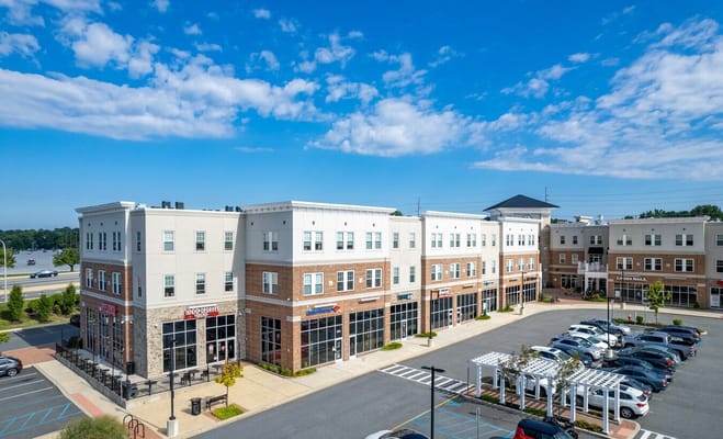 Exterior of Linden Hill Station Apartments featuring retail shops and parking